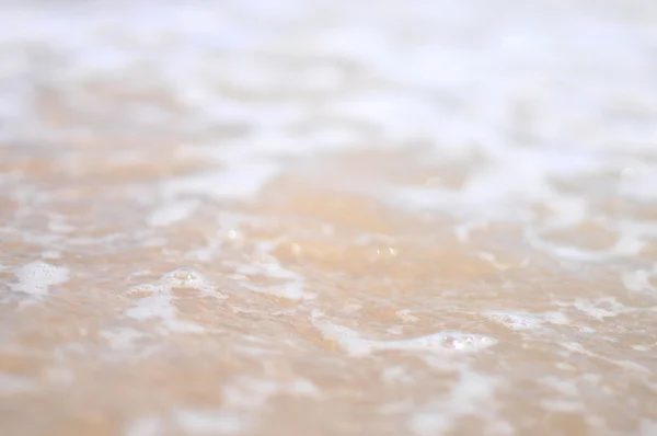 Морские волны над песком — стоковое фото
