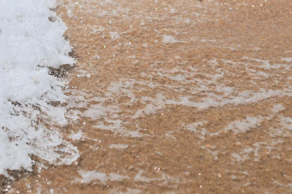 Морские волны над песком — стоковое фото