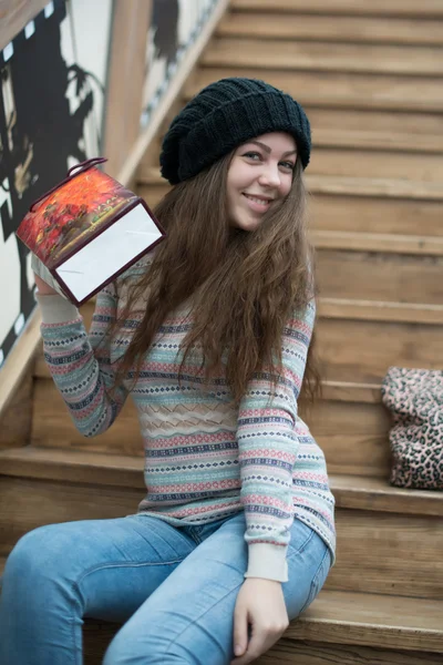 Schönes Mädchen sitzt auf hölzernen Treppen — Stockfoto