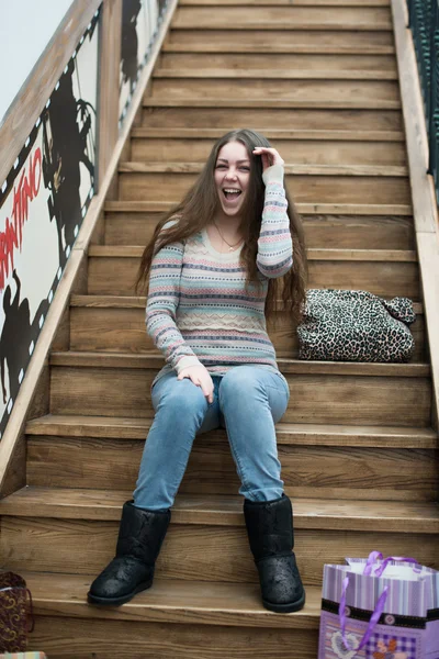 Beautiful girl sitting on wooden stairs — Stock Photo, Image