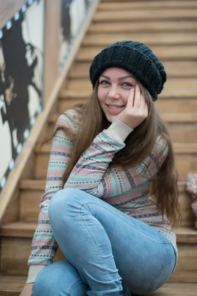 Menina bonita sentada em escadas de madeira — Fotografia de Stock