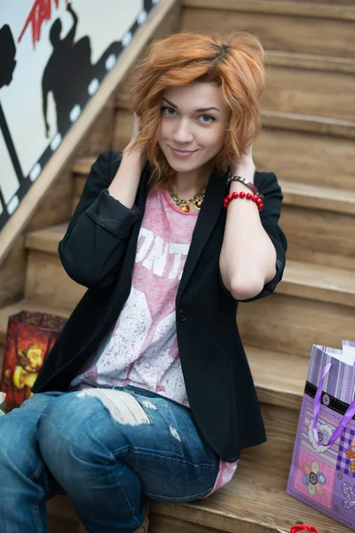 Beautiful girl sitting on wooden stairs — Stock Photo, Image