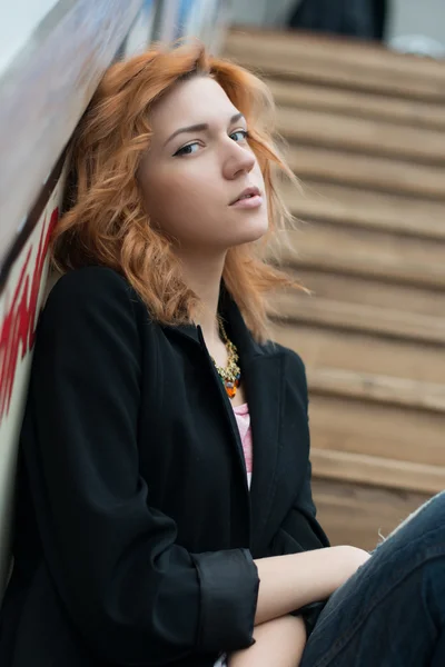 Beautiful girl sitting on wooden stairs — Stock Photo, Image