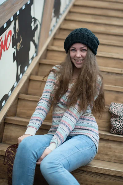Gyönyörű lány ül a fa lépcsők a bolzákon — Stock Fotó