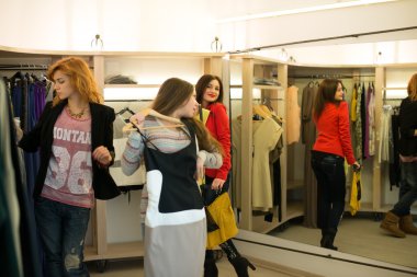 Elbise seçen kadın aynada belirsizdir.