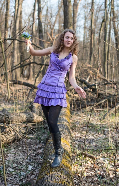 Beautiful girl walking in the woods with a bouquet of snowdrops — Stock Photo, Image