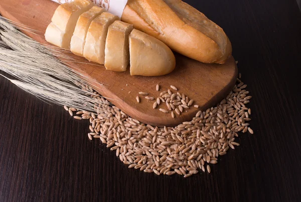Vers brood en tarwe op het hout — Stockfoto