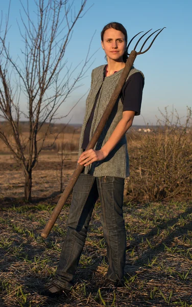 Chica en el trabajo de campo la tierra al atardecer — Foto de Stock