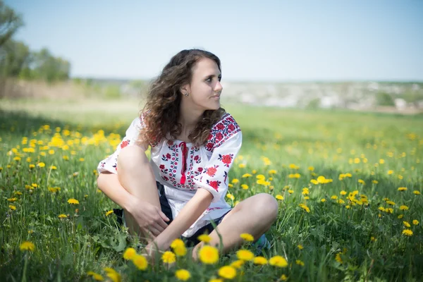 Das junge ukrainische Mädchen mit gelben Blumen — Stockfoto