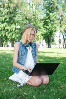 çim çalışma üzerinde oturan karışık ırk üniversite öğrencisi