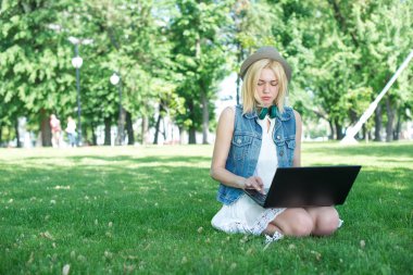 çim çalışma üzerinde oturan karışık ırk üniversite öğrencisi