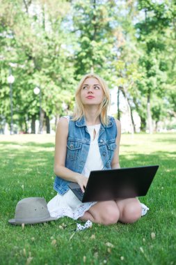 çim çalışma üzerinde oturan karışık ırk üniversite öğrencisi