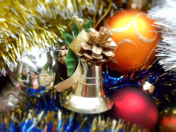 Kerstmis en Nieuwjaar decoraties ballen en bell op een klatergoud achtergrond — Stockfoto