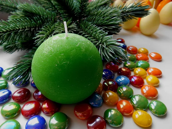 Weihnachts- und Neujahrsdeko-Baumkerze und farbige Steine — Stockfoto