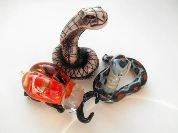 Serpent décoratif en céramique et coléoptère de verre sur fond blanc — Photo