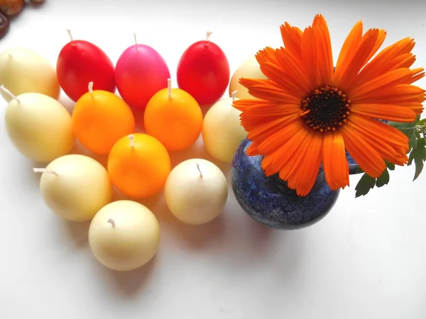着色された卵のキャンドルとオレンジの花の美しい背景 — ストック写真