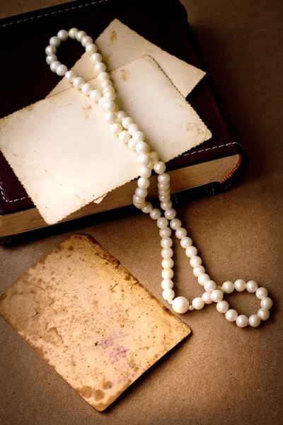 Retro picture of a necklace lying on a book — Stock Photo, Image