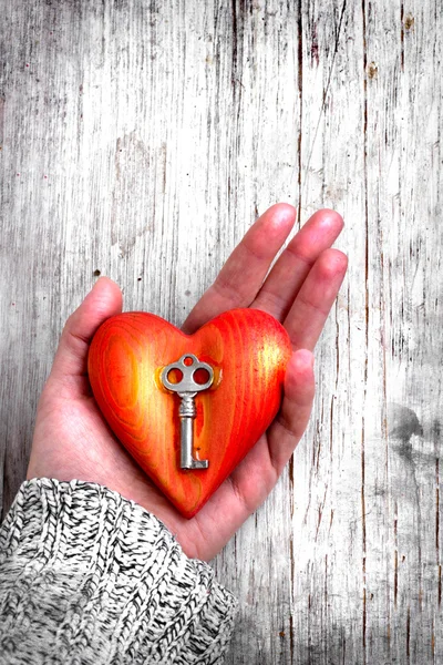 Cuore con la chiave nella mano delle donne come simbolo di amore — Foto Stock