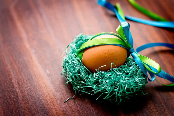 Uova su tavolo di legno con un nastro verde — Foto Stock