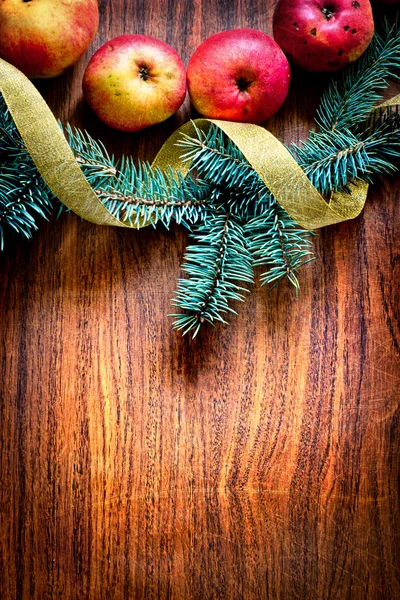 A karácsonyfát almával és egy fából készült fedélzet dekoráció — Stock Fotó