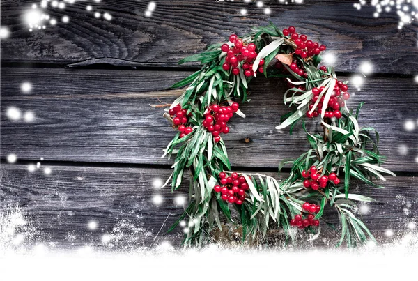 Noel kartı ile doğal dekorasyon kopya alanı bir kar ile birlikte bir rustik ahşap duvarda asılı olan çelenk