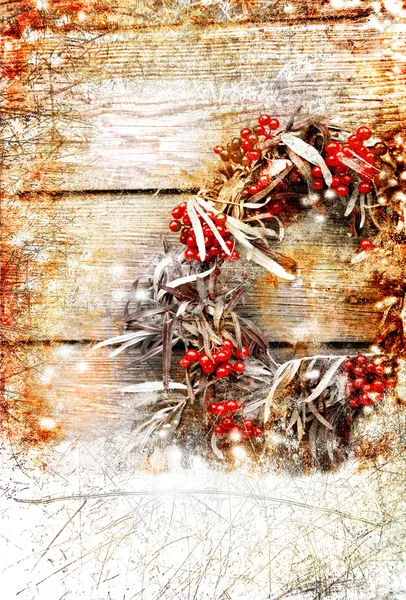 Christmas card with wreath with natural decorations hanging on a rustic wooden wall with copy space with a snow — Stock Photo, Image