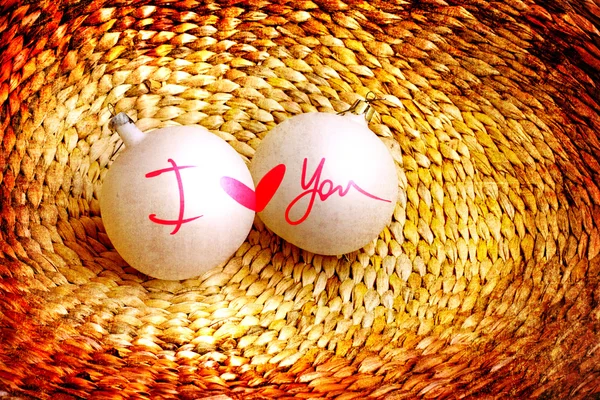 Two baubles with words "I love you " and heart on vine woven basket — Stock Photo, Image