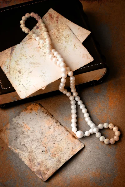 Retro picture of a necklace lying on a book — Stock Photo, Image