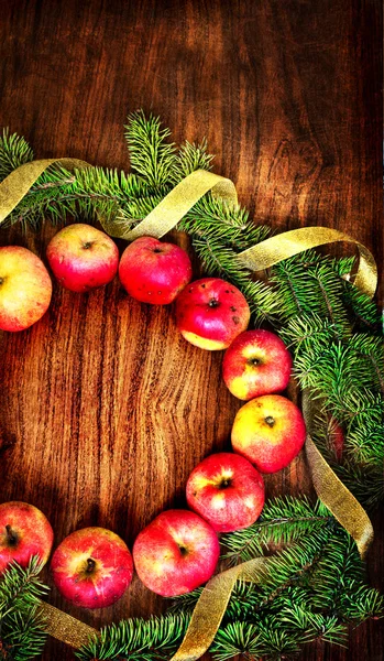 Christmas tree with apples and decorations on a wooden board — Stock Photo, Image