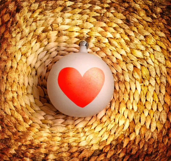 Bauble with heart on vine woven basket — Stock Photo, Image