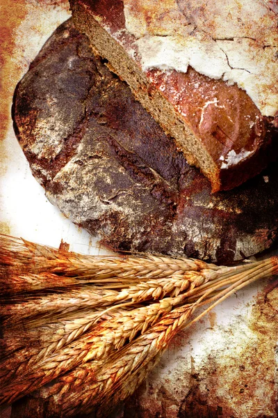 Still life with black bread and ears of wheat — Stock Photo, Image