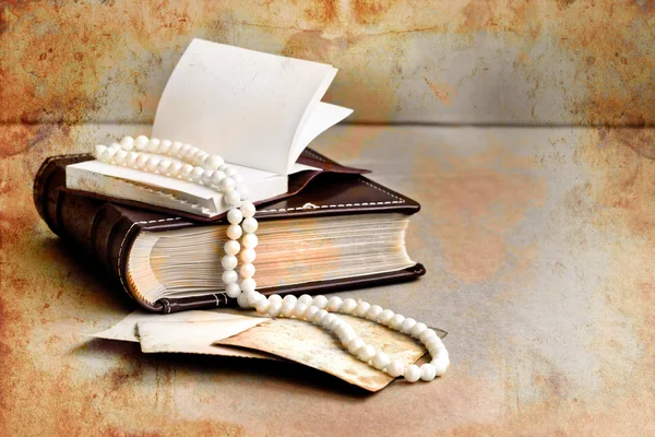 Retro picture of a necklace lying on a book, romantic vintage background with and blank page — Stock Photo, Image