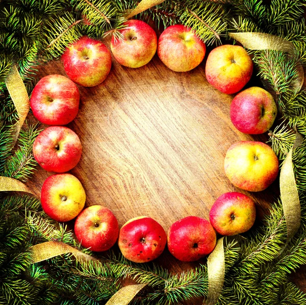 Christmas tree with apples and decorations on a wooden board — Stock Photo, Image