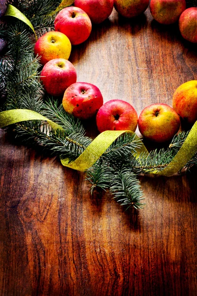 Christmas tree with apples and decorations on a wooden board — Stock Photo, Image