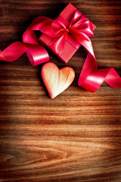 Vintage Holidays gift with a bow from ribbon and peace of paper for the wishes on wooden background. — Stock Photo, Image