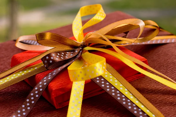 Two foil gifts with yellow,gold,brown bows — Stock Photo, Image