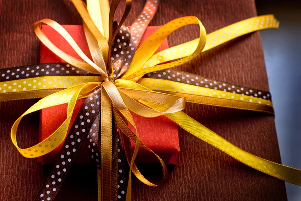 Two foil gifts with yellow,gold,brown bows — Stock Photo, Image