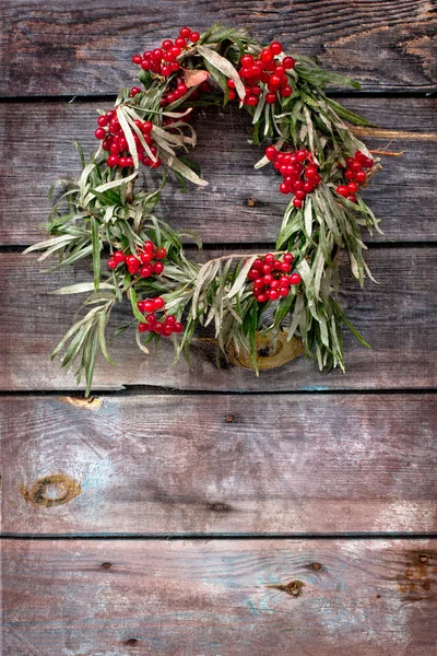 Wreath of leaves with rowan on wooden grunge background — Stock Photo, Image