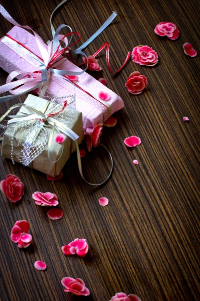 Vintage Retro Present,gift bow with petal from flowers on wooden table — Stock Photo, Image