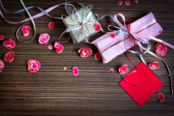 Винтажный ретро подарок, подарочный бант с лепестком из цветов на деревянном столе — стоковое фото