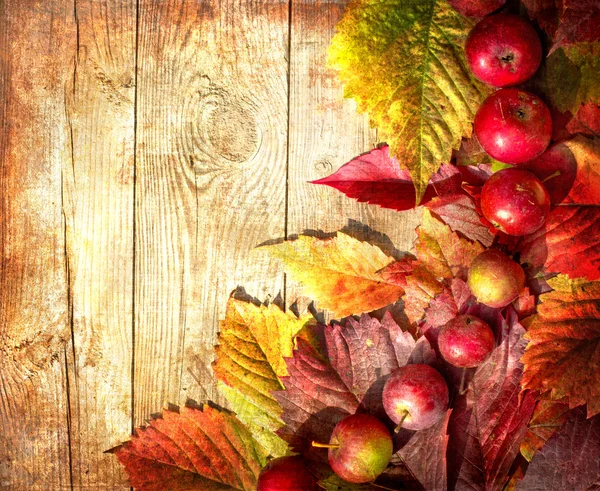 Vintage frontera de otoño de manzanas y hojas caídas en la vieja mesa de madera —  Fotos de Stock