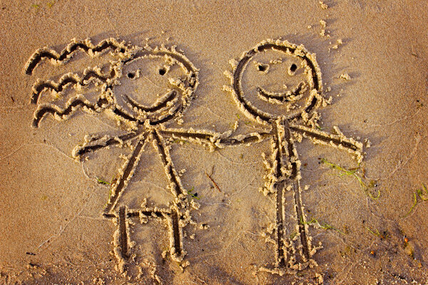 Мальчик и девочка, нарисованные в песке
