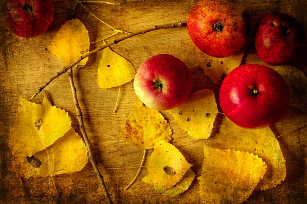 Bushel of red apples and autumn leaves