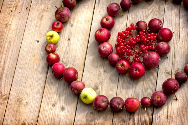 Vintage Autumn border from apples and fallen leaves on old wooden table. — Stock Photo, Image