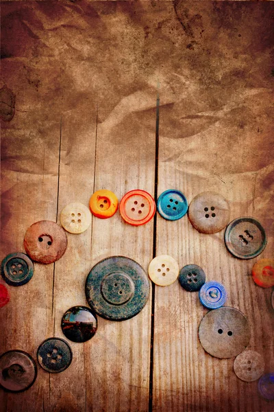 Set of vintage buttons on old wooden table with grunge texture — Stock Photo, Image