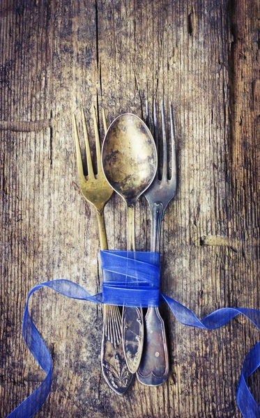 Винтажные ложки и вилки с голубым бантом — стоковое фото