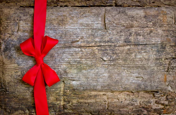 Red ribbon over wooden background — Stock Photo, Image