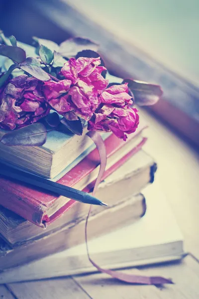 Dry roses on old books — Stock Photo, Image