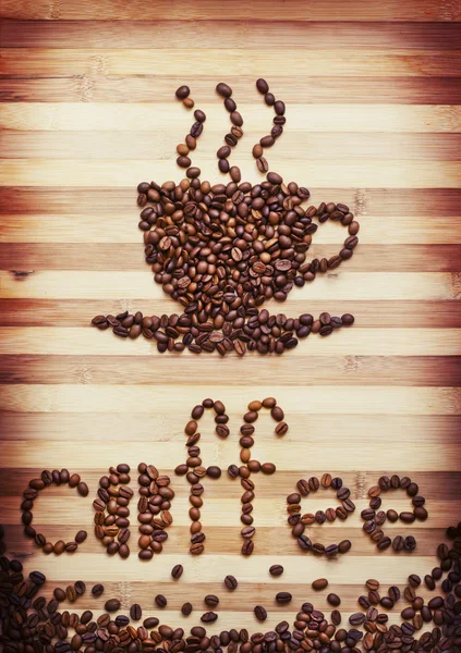 Кофейные зерна, образующие слово "кофе" и чашку кофе — стоковое фото
