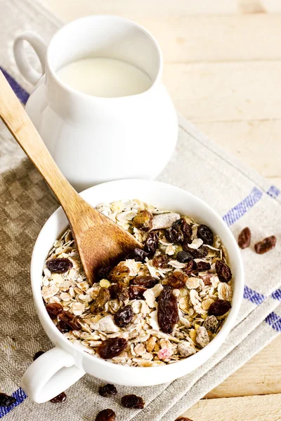 Bowl of oat flakes with raisins and milk — Stock Photo, Image